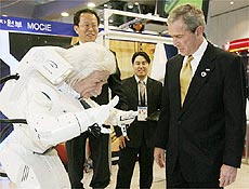 Alex Hubo, em foto tirada em feira na Ásia, saúda o presidente dos EUA, George Bush