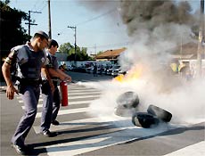 Policiais apagam fogo em pneus
