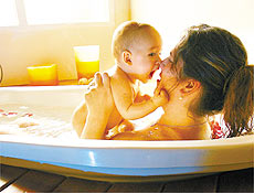 Isabel Maranho, 36, faz banho de imerso acompanhada do filho Ian, de quatro meses
