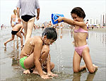 Crianas brincam no mar na praia do Boqueiro, em Praia Grande (SP).