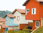 Três casas de vila pintadas com tinta à base de terra, da Primamatéria