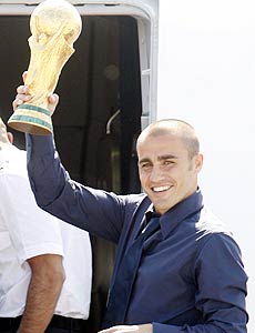 Zagueiro Fabio Cannavaro exibe a taça Fifa antes do embarque para a Itália; veja mais