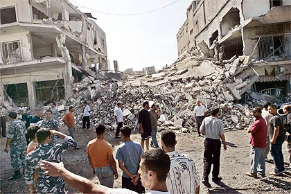 Libaneses olham prédio destruído por ataque aéreo israelense, em Nabatiyeh, Líbano