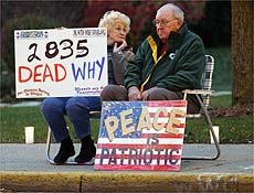 Casal protesta contra Guerra do Iraque, em Wisconsin; polcia encontra corpos em Bagd