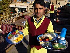 Garçom serve comida em restaurante de Isfahan