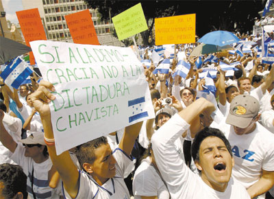 Simpatizantes do presidente interino Roberto Micheletti se manifestam em Tegucigalpa com cartaz que critica 