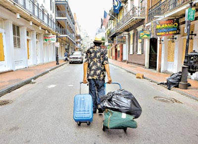 Morador deixa a Bourbon Street, em Nova Orleans, diante da ordem de evacuar a cidade antes da chegada do furaco Gustav