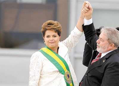 Depois de recebera faixa presidencial de Lula, Dilma Rousseff e o antecessor saúdam o público em cerimônia no Palácio do Planalto