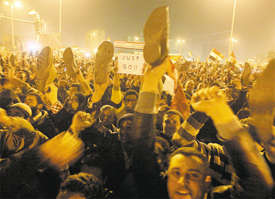 Manifestantes mostram sapatos sobre as cabeas, gesto ofensivo no mundo rabe, em ato contra o ditador Mubarak na praa Tahrir (Cairo)