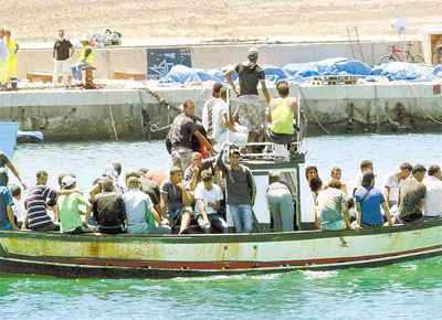 <b>SUFOCO</b>: Imigrantes passam diante de caixes e corpos no porto de Lampedusa (Itlia); 25 morreram em poro de navio vindo da Lbia