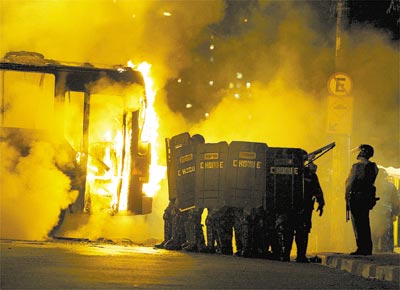 Diante de um nibus incendiado, Tropa<br>de Choque enfrenta manifestantes