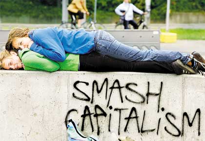 Manifestantes anticpula do G8 descansam sobre muro com a pichao 