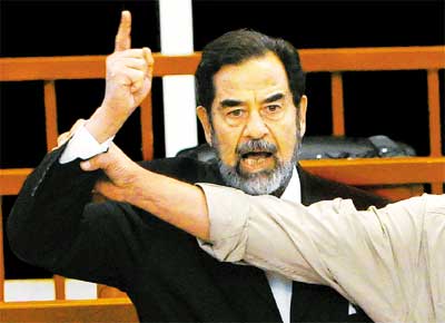 O ex-ditador Saddam Hussein protesta em corte de Bagd enquanto recebe a sentena de morte por massacre de xiitas em 1982