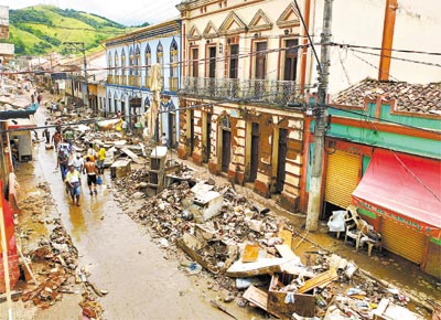 Moradores de So Luiz do Paraitinga (SP) entre os escombros deixados pela chuva na cidade; estima-se que pelo menos 300 prdios histricos tenham sido afetados