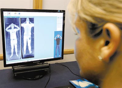 Agente de segurana do aeroporto de Manchester (Reino Unido) observa monitor de scanner corporal, aparelho que a Itlia vai adotar