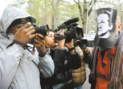 Em Londres, manifestante usando mscara com a imagem de Julian Assange desperta a ateno de fotgrafos