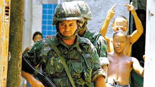 Soldados patrulham favela de Manguinhos (Rio), enquanto garotos fazem gestos obscenos