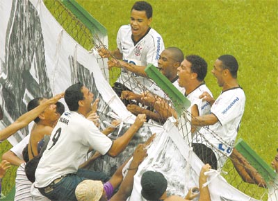 Junto com Dentinho (no alto,  esquerda), Elias e Cristian, Ronaldo sobe no alambrado, que ruiu, para comemorar com a torcida