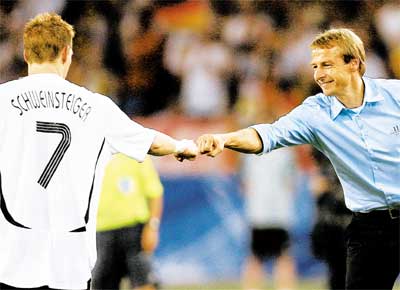 O tcnico Klinsmann cumprimenta Schweinsteiger, autor de 2 gols na vitria de 3 a 1 contra Portugal