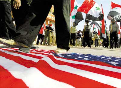 Iraquianos pisam em bandeira dos EUA durante protesto de 600 mil xiitas contra a ocupao americana nos 4 anos da queda de Bagd