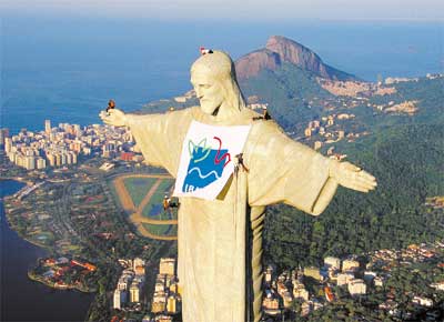 Aps Cristo ser eleito uma das novas maravilhas do mundo, alpinistas estendem faixa no monumento em protesto contra a diviso do Ibama