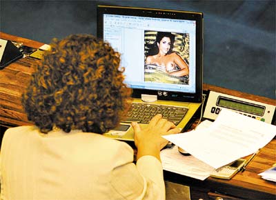 A senadora Ideli Salvatti, que defendia Renan Calheiros, olha na internet fotografia da jornalista Mnica Veloso na 'Playboy'