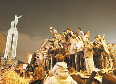 Manifestantes contrrios a Hosni Mubarak festejam sobre tanque do Exrcito sua sada do poder; ditador foi para o balnerio no Sinal