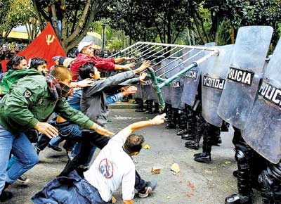 Manifestantes atacam barreira policial em protesto aps a chegada do presidente dos EUA, George W. Bush, a Bogot (Colmbia)