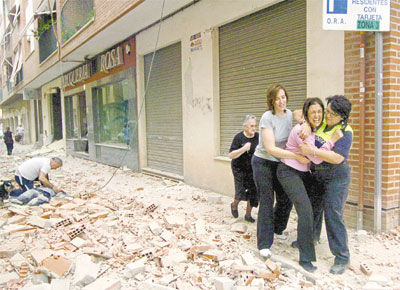 Homem socorre pedestre atingido por desabamento provocado por tremor em rua da cidade de Lorca (sudeste espanhol); dois terremotos, de magnitude 4,5 e 5,1, deixaram ao menos oito mortos no pas