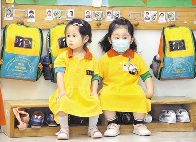 Criana com mscara ao lado de colega em Hong Kong, onde autoridades decidiram fechar escolas por duas semanas devido  gripe