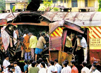 Indianos procuram corpos de vtimas em vago de um dos trens atingidos por exploses numa estao ferroviria em Mumbai