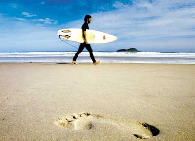 Surfista na praia do Tombo, no Guaruj (SP), uma das dez praias brasileiras que tentam conquistar um certificado de qualidade socioambiental conhecido como 
