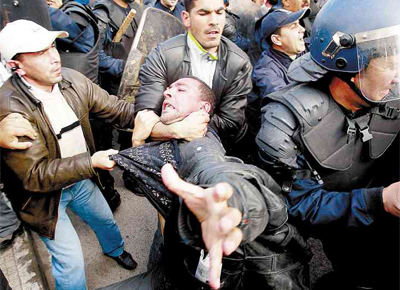 <b>EFEITO DOMIN?</b> Policiais  paisana agarram ativista durante protesto por reformas que reuniu milhares de pessoas em Argel (Arglia)