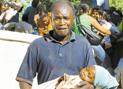 Haitiano ferido no terremoto em Porto Prncipe carrega a filha morta; agncias humanitrias tm dificuldades para enviar pessoal