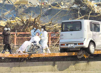 Paciente  conduzida sobre ponte parcialmente destruda aps ser retirada de hospital afetado pelo tsunami na cidade de Otsuchi