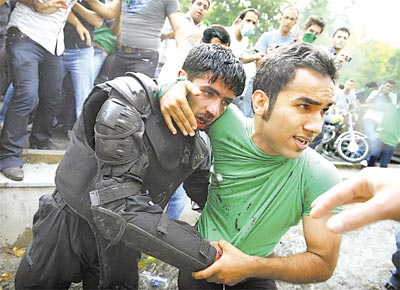 Partidrio do reformista Mousavi ajuda a socorrer<br>policial ferido durante os protestos em Teer