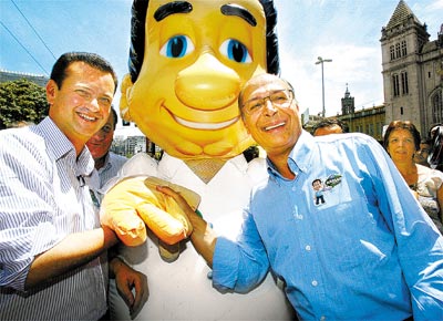 O ex-governador Geraldo Alckmin (PSDB), derrotado no 1 turno, posa ao lado de Kassab e de boneco do prefeito, no centro de SP