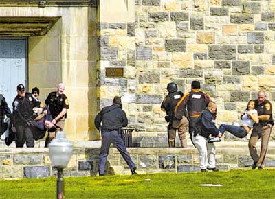 Feridos so retirados do edifcio que concentrava aulas de engenharia na universidade Virginia Tech, onde um atirador matou 32 pessoas