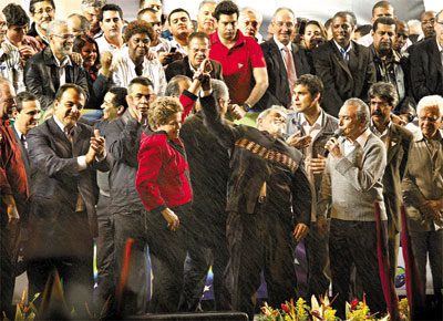 Ao lado de Michel Temer (dir.), candidato a vice, Lula ergue brao de Dilma em palanque