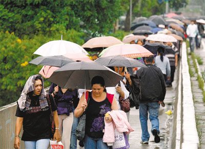 <b>NA RUA, NA CHUVA:</b> Usurios do metr caminham pelo viaduto Dante Delmanto (zona sul paulistana)