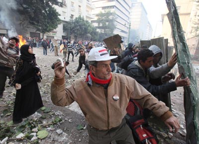 <b>LONGA PRIMAVERA</b>: Egpcio joga pedra contra policiais em protesto que deixou dois mortos e 220 feridos no Cairo