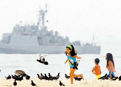 Crianas brincam em Copacabana, no Rio, onde embarcao das Foras Armadas refora a segurana para a Cpula do Mercosul