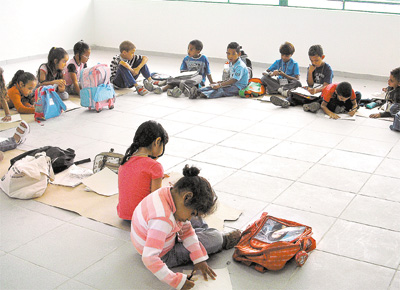 Alunos de escola estadual na zona sul de SP se sentam no cho, sobre pedaos de papelo, devido  falta de carteiras no primeiro dia de aula