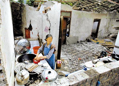 <B>UMA SEMANA DEPOIS</B>: Mulher lava loua na cozinha de sua casa em Sichuan, destruda pelo terremoto que matou 32.476 pessoas na China
