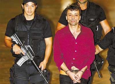 O ex-ativista italiano Cesare Battisti, preso no Rio,  escoltado ao chegar a Braslia