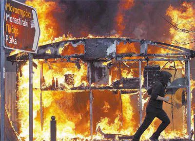 Banca de jornal queima em Atenas, onde 70 mil manifestantes, segundo a polícia, enfrentaram cassetetes e gás com pedras e coquetéis molotov