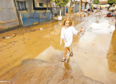 Em So Caetano (SP), menina caminha por rua enlameada aps chuva de anteontem  noite, que causou estragos no ABC e na capital