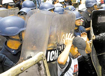 Manifestante tenta conter policiais durante confronto em Caracas entre as foras de segurana e milhares de estudantes contrrios  reforma constitucional proposta por Hugo Chvez