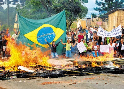 Sem-teto pem fogo em galhos e formam barreira humana para evitar reintegrao de posse em terreno na periferia de Curitiba