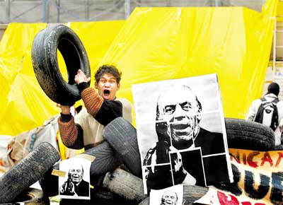 Invasor da reitoria da USP segura pneu em barricada feita por alunos e funcionrios, cujo sindicato foi proibido por ordem da Justia de fazer piquetes no campus